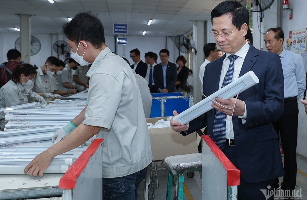 Bộ trưởng Nguyễn Mạnh Hùng đang chăm chú xem sản phẩm bóng đèn được sản xuất bởi Rạng Đông.